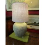 A large terracotta table lamp base in a verdigris, bronze effect, finish with shade