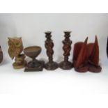 A box of wooden items including a pair of turned candlesticks, owl figure