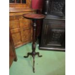 A George III style mahogany circular dish top torchere on turned and fluted column on a tripod base.