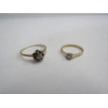 A 15ct and platinum diamond (0.10 carat) solitaire ring and 9ct floral ring (2) 4g total