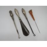 Two silver button hooks a shoe horn all with silver handles and a Bakelite hat pin