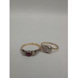 A 9ct gold and platinum crossover ring set with central diamond chip and a gold, ruby and diamond