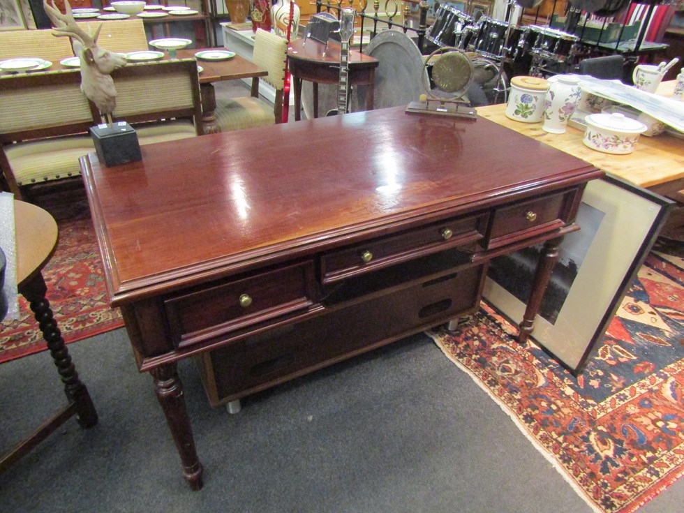 A Victorian style writing table of three faux and three frieze drawers on turned and carved legs.