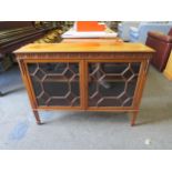 An early 20th Century walnut low bookcase, astragal glazed doors, on spade legs, 76cm high x 101cm