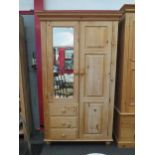 A natural pine compactum wardrobe with mirrored door over three drawers and full height door,