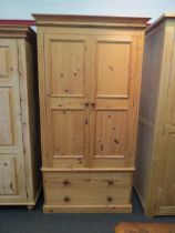 A natural pine compactum wardrobe, the two doors over two drawers, 200cm high x 104cm wide x 55cm