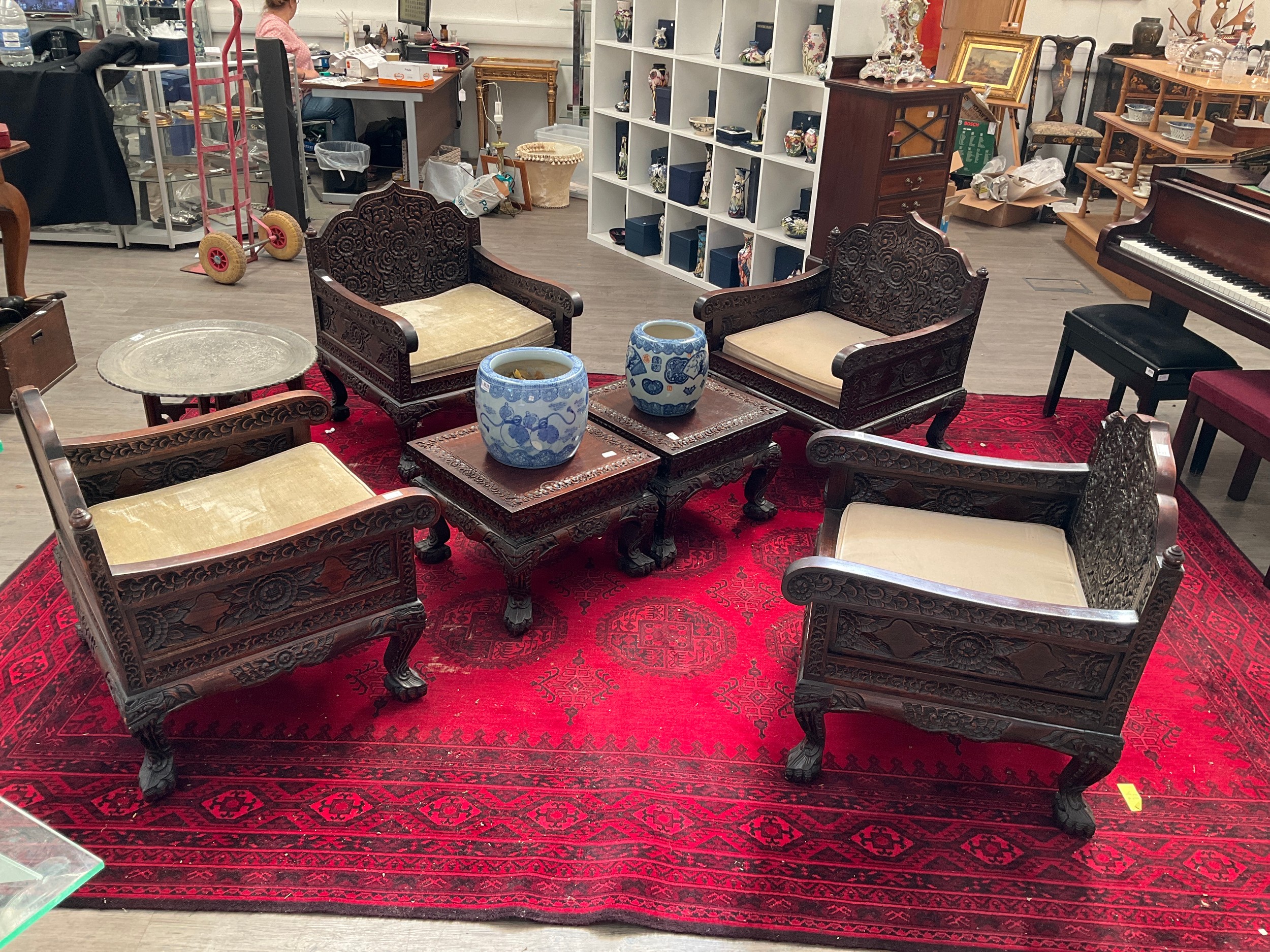 An early 20th Century Chinese rosewood lounge suite consisting of four heavily carved armchairs