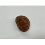 A Late 19th/early 20th Century African carved nut vinaigrette in the form of a man's head