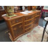 A Georgian style serpentine front burr walnut sideboard with two door cupboard and six drawers (with