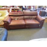 A "Natuzzi" Italian brown leather two seater electric recliner sofa with adjustable head rests (each