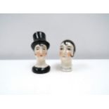 Two porcelain female cushion heads, lady wearing top hat and pierrette 6cm & 5cm tall