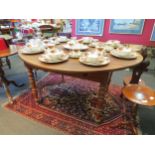 A late 19th Century fruitwood kitchen table with drop sides on turned legs