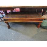 An Eastern hardwood coffee table with glass top of lattice weave panels