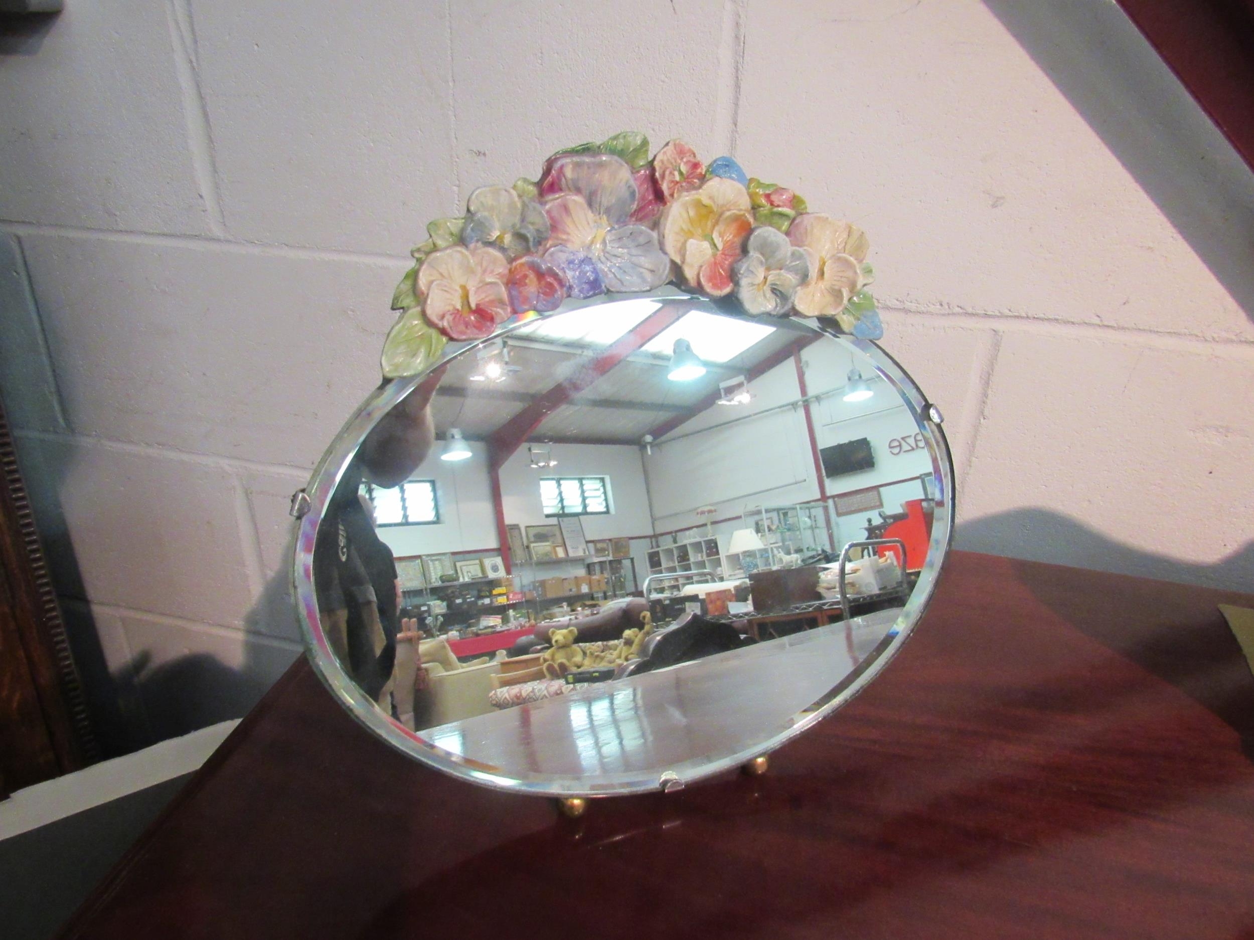 A decorative oval barbola mirror