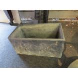 A lead oblong planter with cherubic relief, 20cm high x 38cm long x 21cm wide