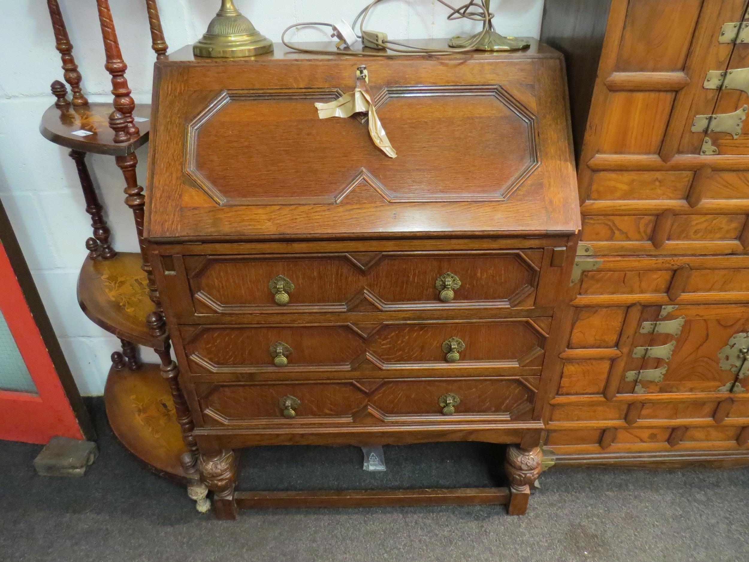 A 20th Century oak bureau, drop flap over three drawers to stretcher base, 103cm high x 78cm wide