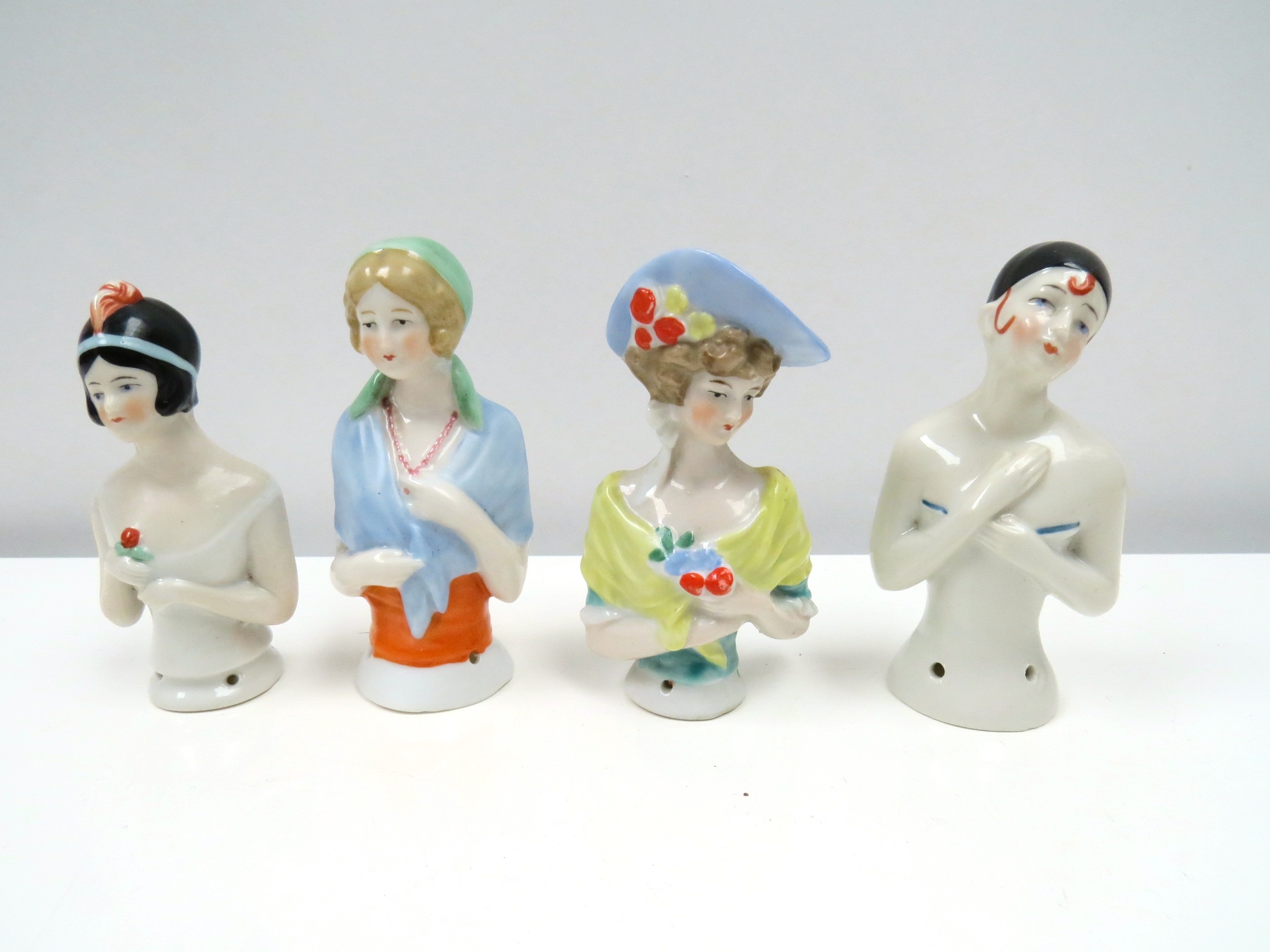 Four early 20th Century glazed china half-dolls including Pierrette, tallest 9cm tall