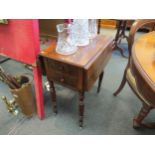 A Victorian mahogany sewing table with cupboard door and two drawers over recessed drawer, turned