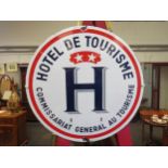 A vintage enamel "Hotel de Tourisme" sign, 40cm diameter