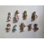 Nine early 20th Century glazed china pin cushion dolls