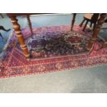 An eastern wool rug with red ground central lozenge and multiple borders a/f 163cm x 120cm
