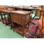 Circa 1920 a two tiered oak work box, the hinged lid over square tapering legs joined by a galleried