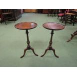 A pair of George III revival mahogany wine tables the dished circular top on a turned column and