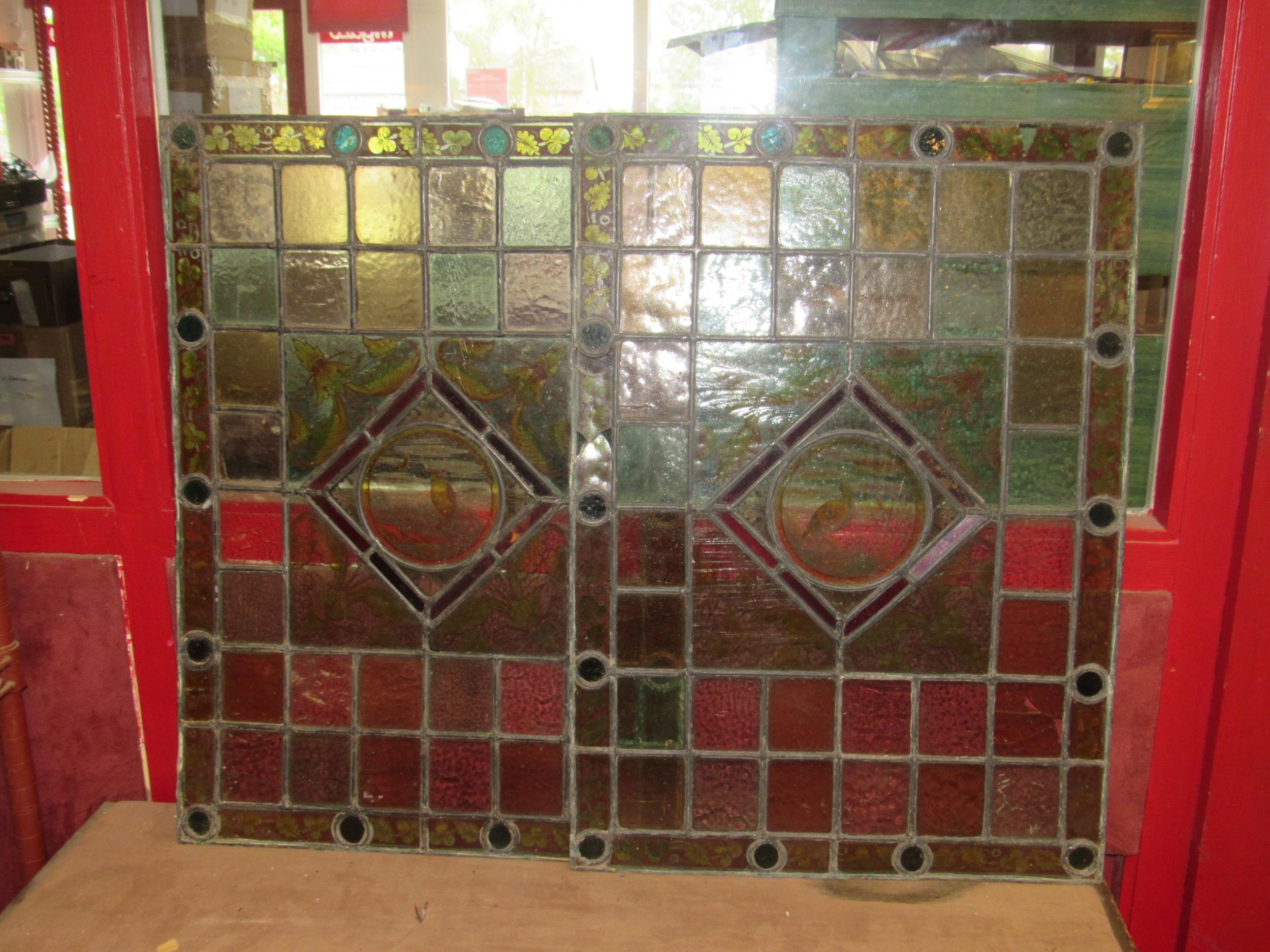 A pair of leaded/stained glass windows each 64cm x 46cm with avian/foliate decoration, a/f