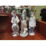 Three Lladro figurines including clown musicians, approximately 23cm high