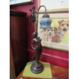 A vintage table lamp in the form of an Art Deco style bronzed lady and with a mottled blue glass