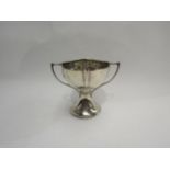 A two handled silver trophy form bowl, dented, 10cm high