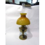 A brass oil lamp with glass shade