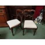 A set of four William IV rosewood chairs the carved back rests over suede covered seats on turned