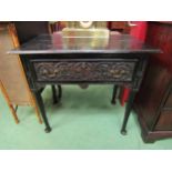 Circa 1800 an ebonised oak lowboy the single frieze drawer with green man carved decoration on