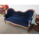 A Victorian walnut hump back settee with deep blue velvet upholstery, scrolled arms and feet, 98cm