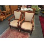 A pair of Irish mahogany chairs with shell detail, scroll arms and reeded legs