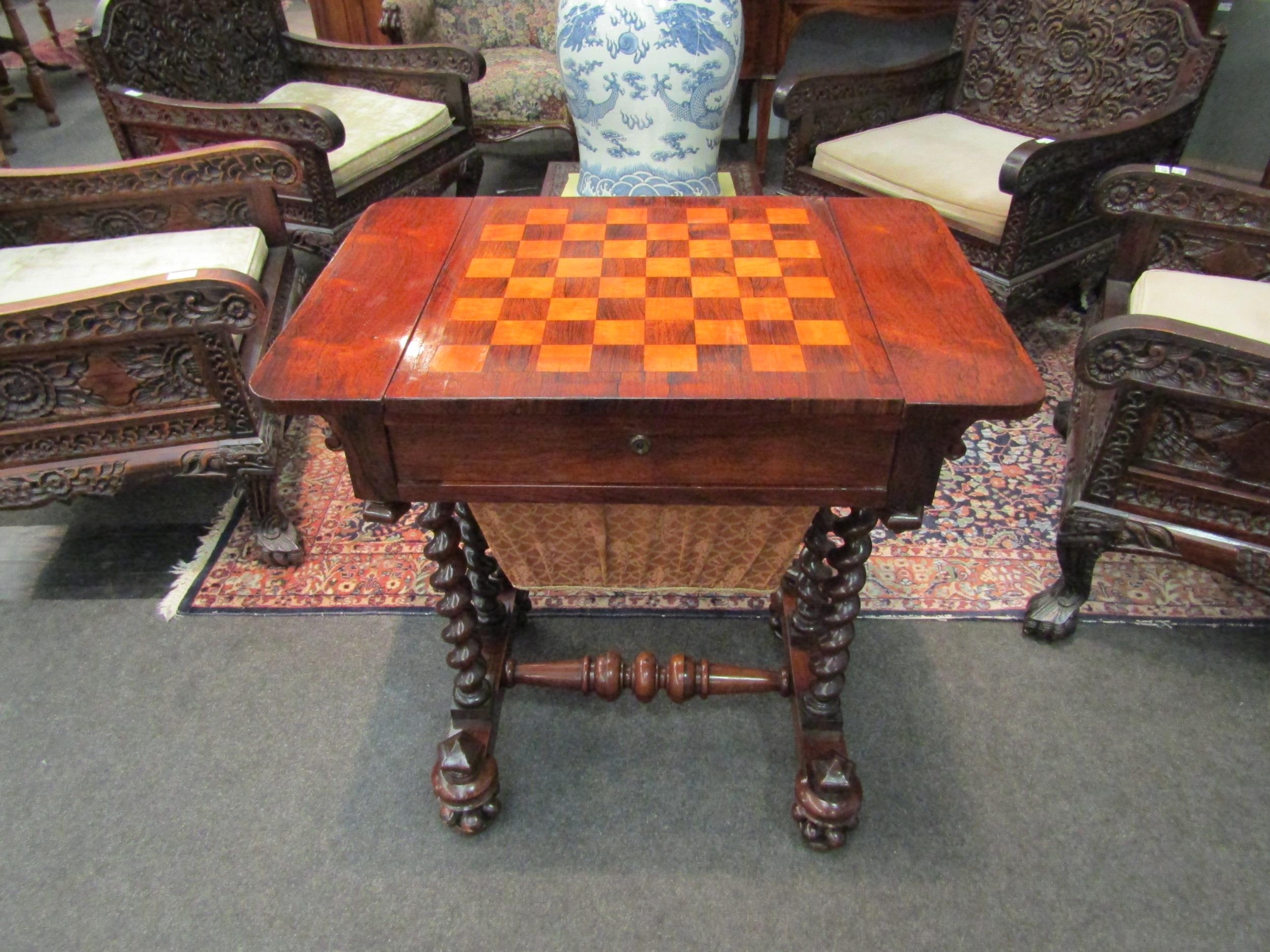 A rosewood games table with chess board/backgammon top with turned supports, on castors