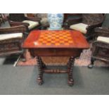A rosewood games table with chess board/backgammon top with turned supports, on castors