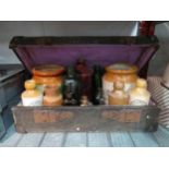 A case containing a selection of glass bottles and stoneware jars, including Grostling and Co,