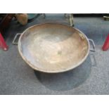 A large copper twin handled bowl, 58cm diameter