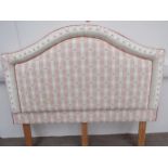 An upholstered and padded headboard, double bed size, green and pink lattice and floral design