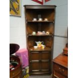 An Ercol full height corner cabinet with shelving over cupboard base, 183cm tall
