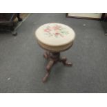 A tapestry seat piano stool on carved tripod legs