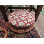 A mid Victorian walnut circular foot stool, the needlepoint seat over three turned feet
