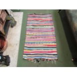 A multi-coloured stripe design small rug, 125cm x 68cm