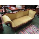 A Victorian hump back sofa with yellow citrus coloured upholstery with scroll arms, turned legs on