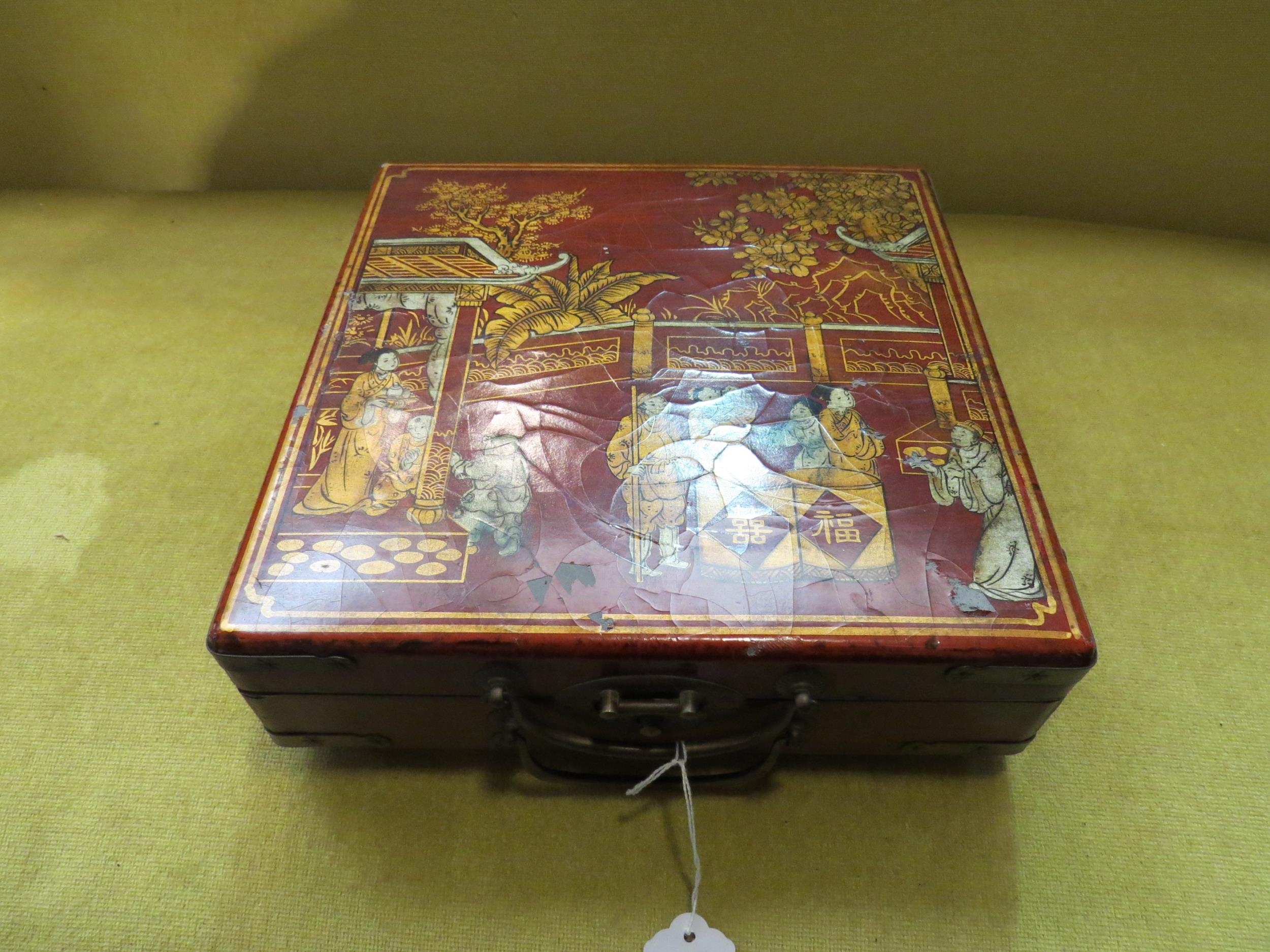 A lacquer box with Oriental design containing a miniature chess set