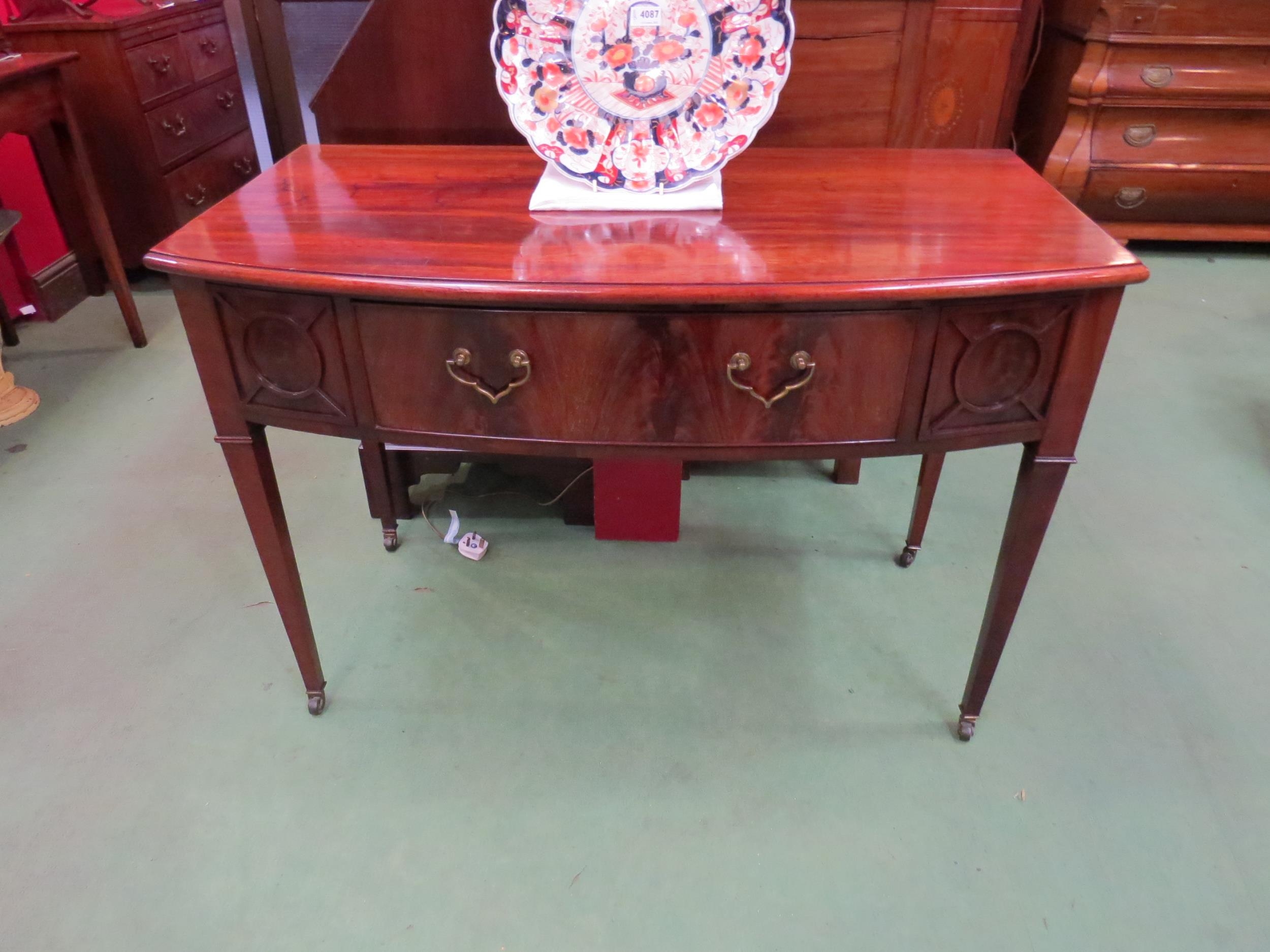 Circa 1860 a flame mahogany bow front side table, the single frieze drawer flanked by moulded panels