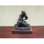 A bronze figure of a lady sitting on a barrel of grapes, on a wooden plinth, 20cm high