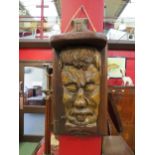 A carved wooden wall sculpture in the form of a face, 44cm high x 20cm wide